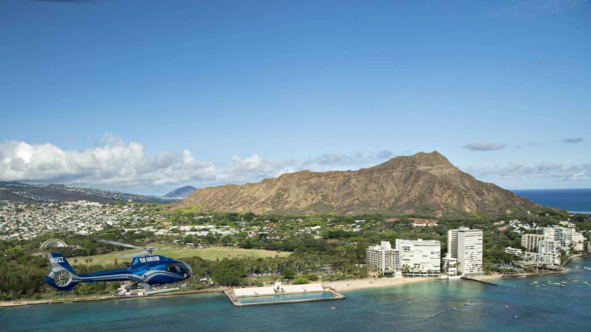 Helicopter flying over the turquoise reefs of Waikiki and Diamond Head on a Honolulu city tour of Oahu from the air, Hawaii